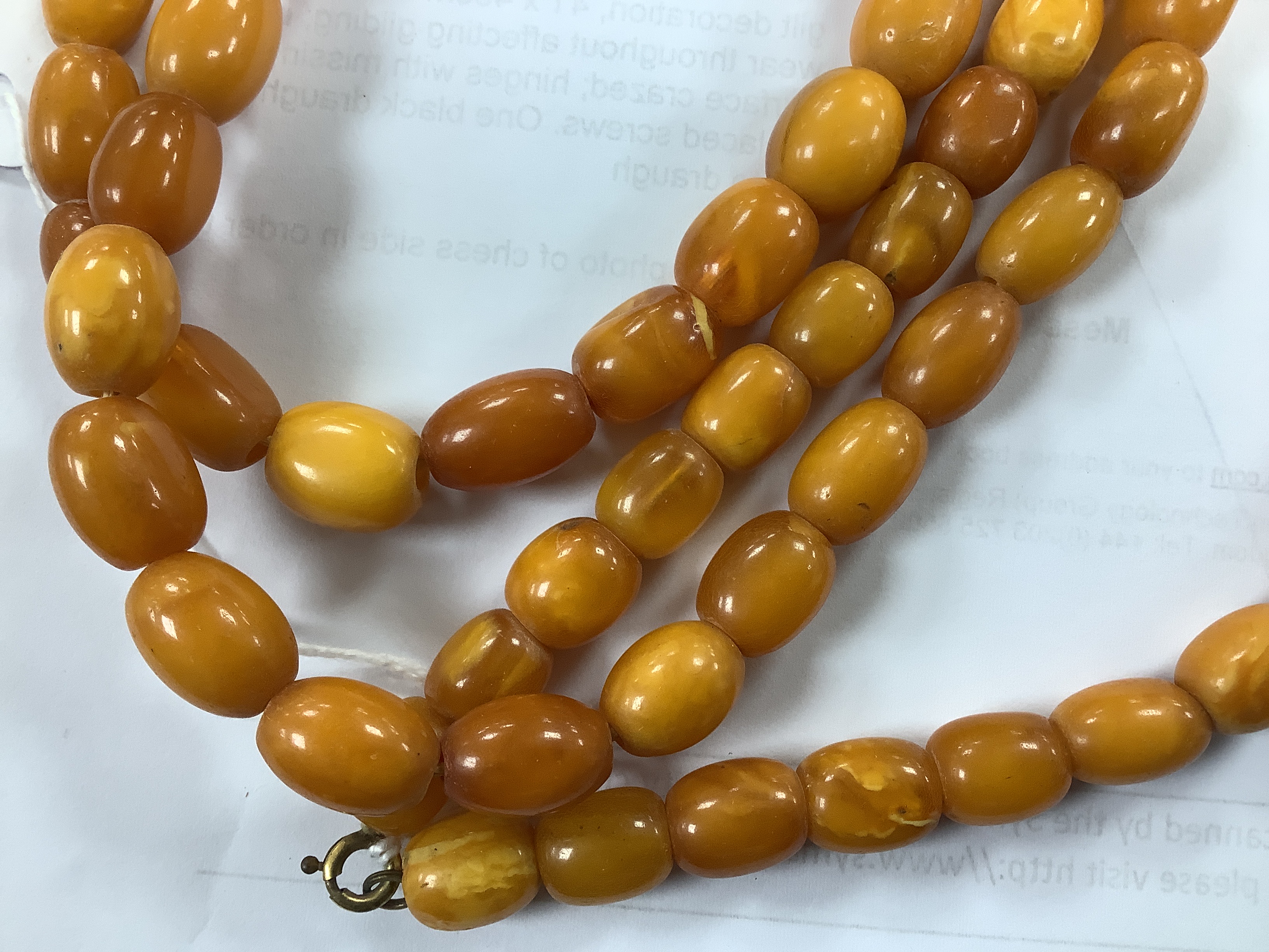 A single strand, barrel and oval amber bead necklace, 108cm, gross weight 76 grams.